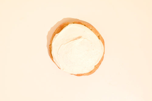 Overhead view of a Pumpkin cookie fully covered in white icing