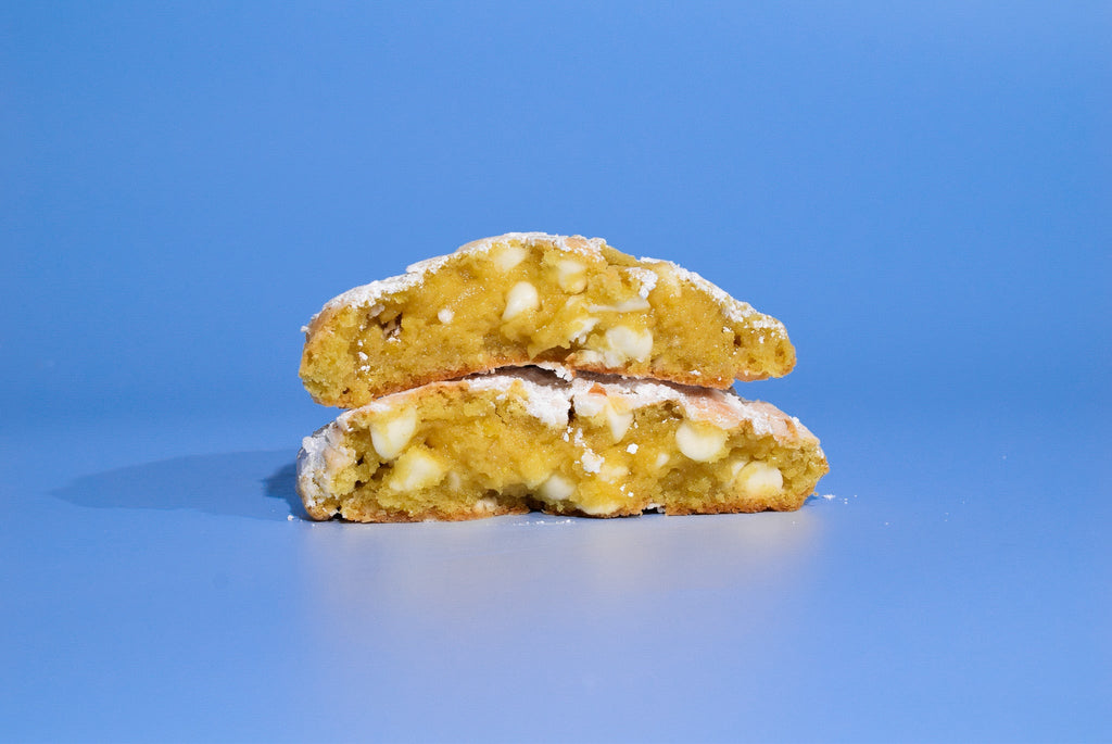 Two cut open Sugar Lemon cookies stacked on a blue background.