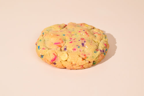 A birthday cake cookie on a cream background.