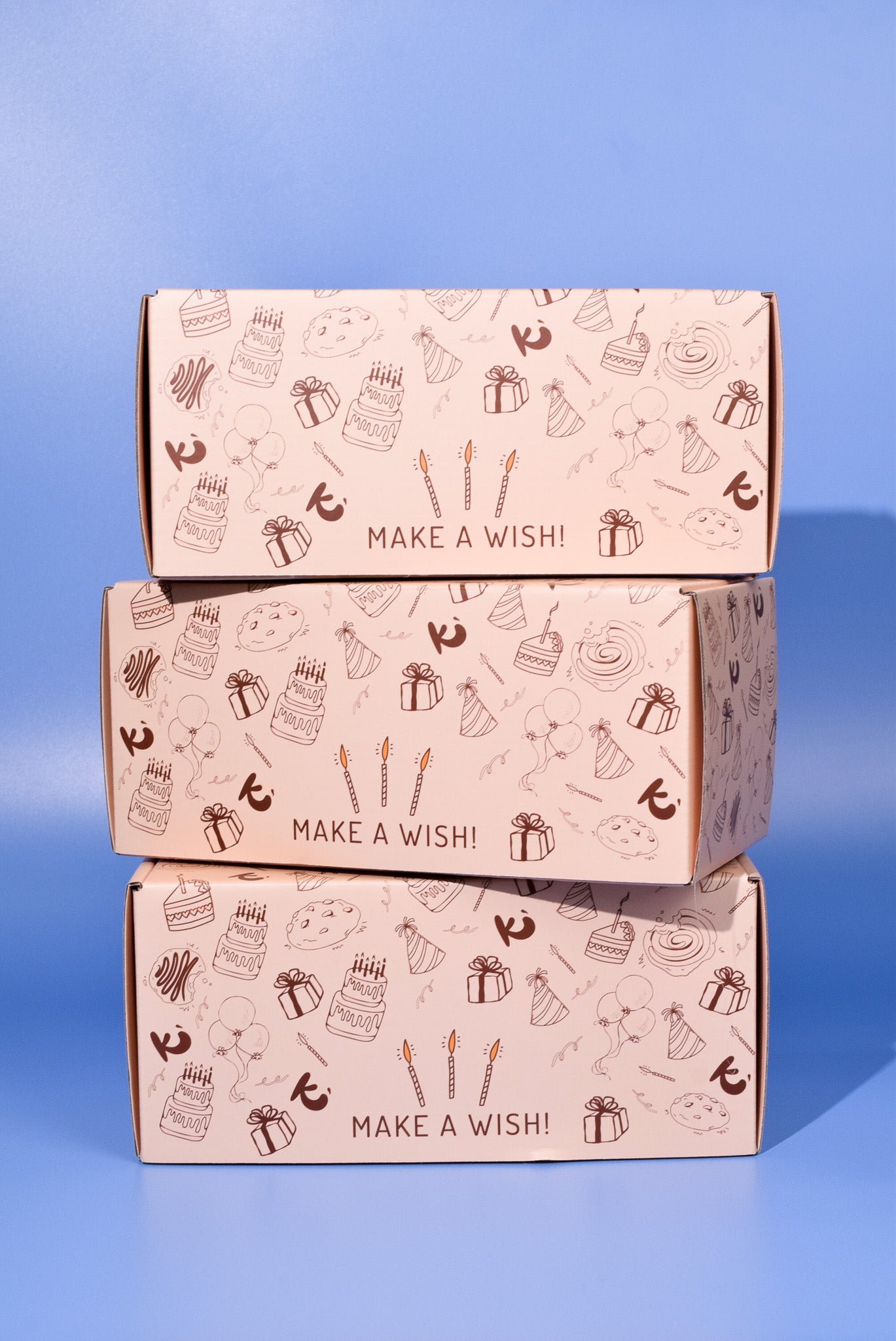 Three Birthday Cookie boxes stacked on top of each other on a blue background