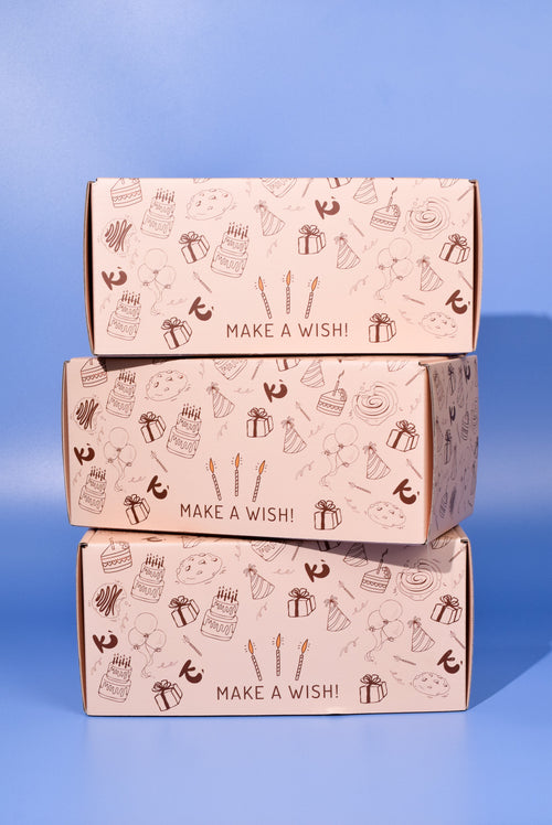 Three Birthday Cookie boxes stacked on top of each other on a blue background
