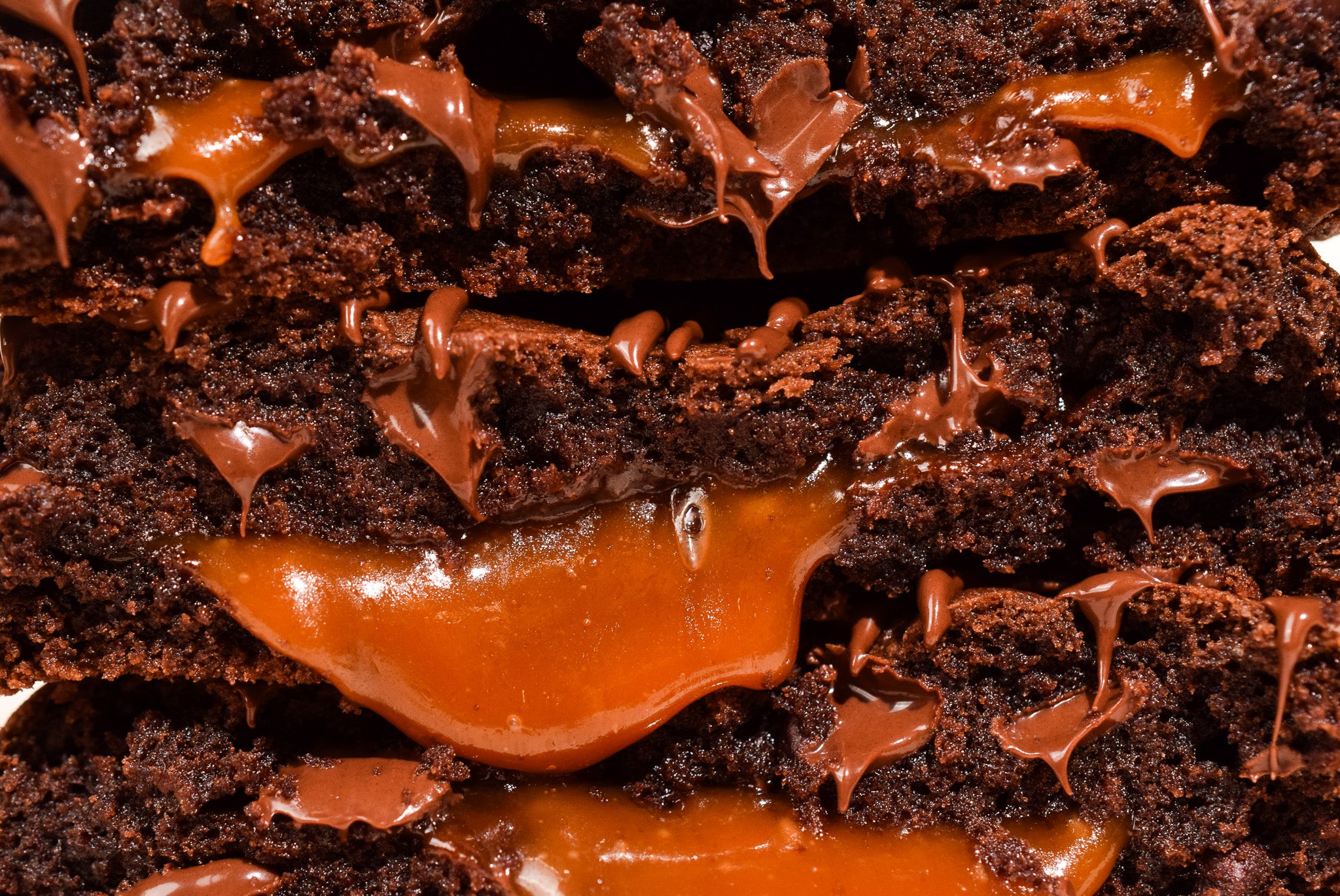 A close up image of a Chocolate Caramel cookie with Caramel oozing out the center.