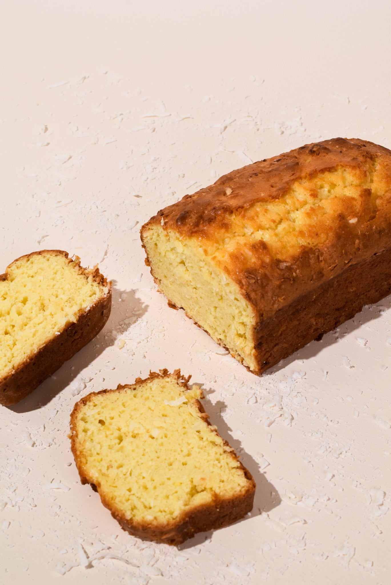 Loaf of bread with two slices on a light surface