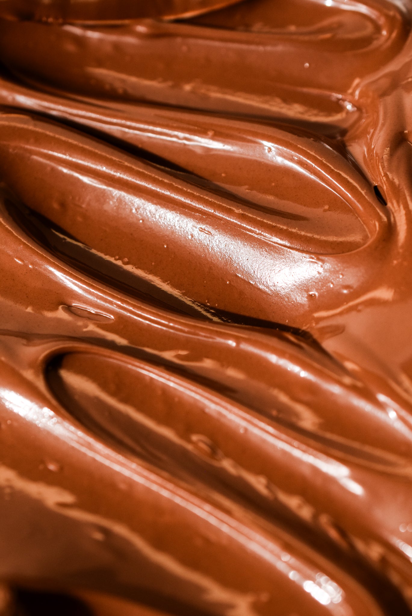 Close-up of smooth, glossy chocolate frosting