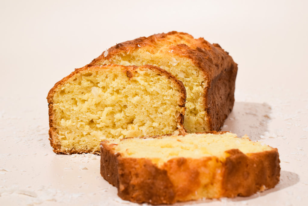 Hawaiian Coconut Loaf with a few slices cut, on a light background