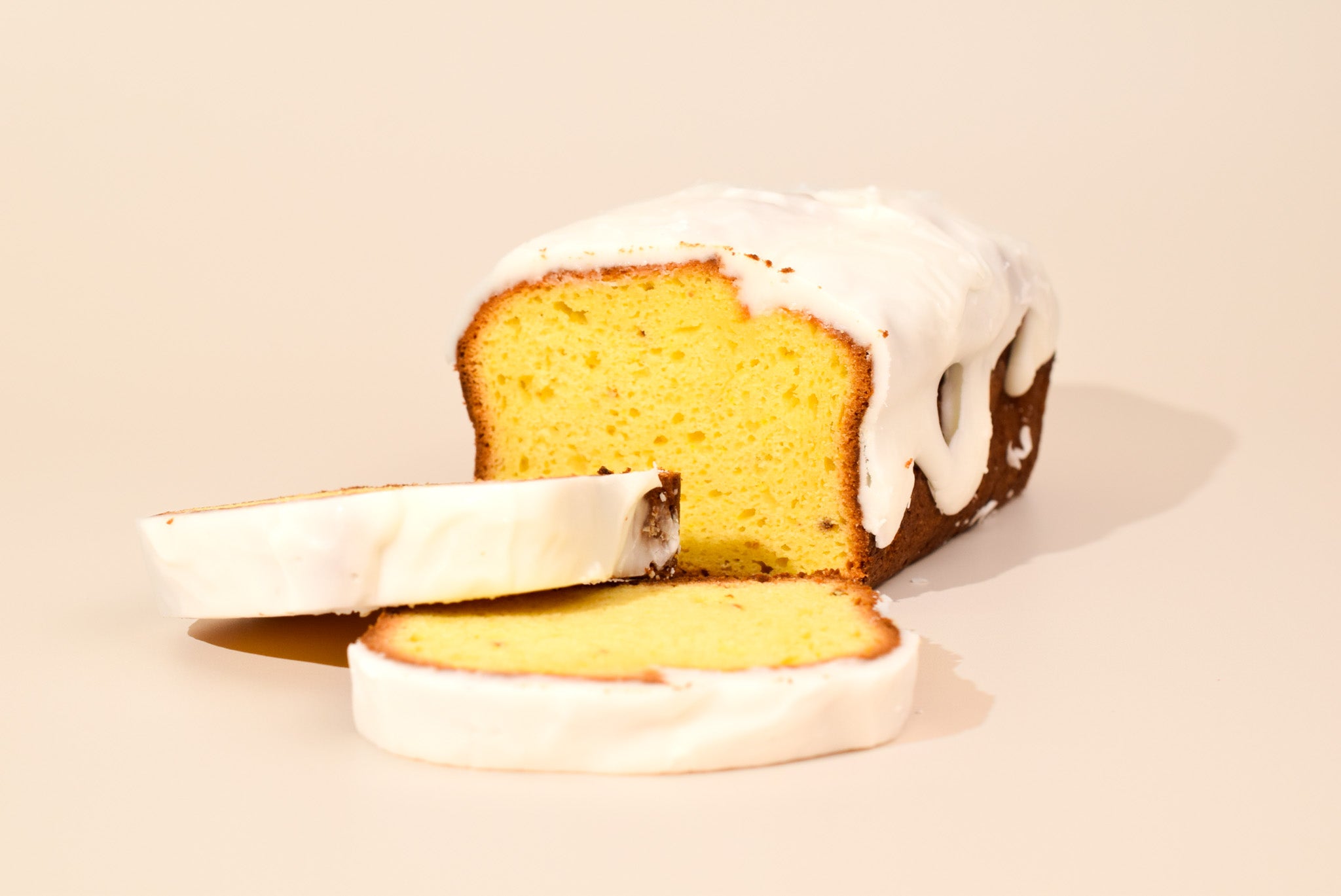 Keksi Lemon Bread with two slices on a cream background.