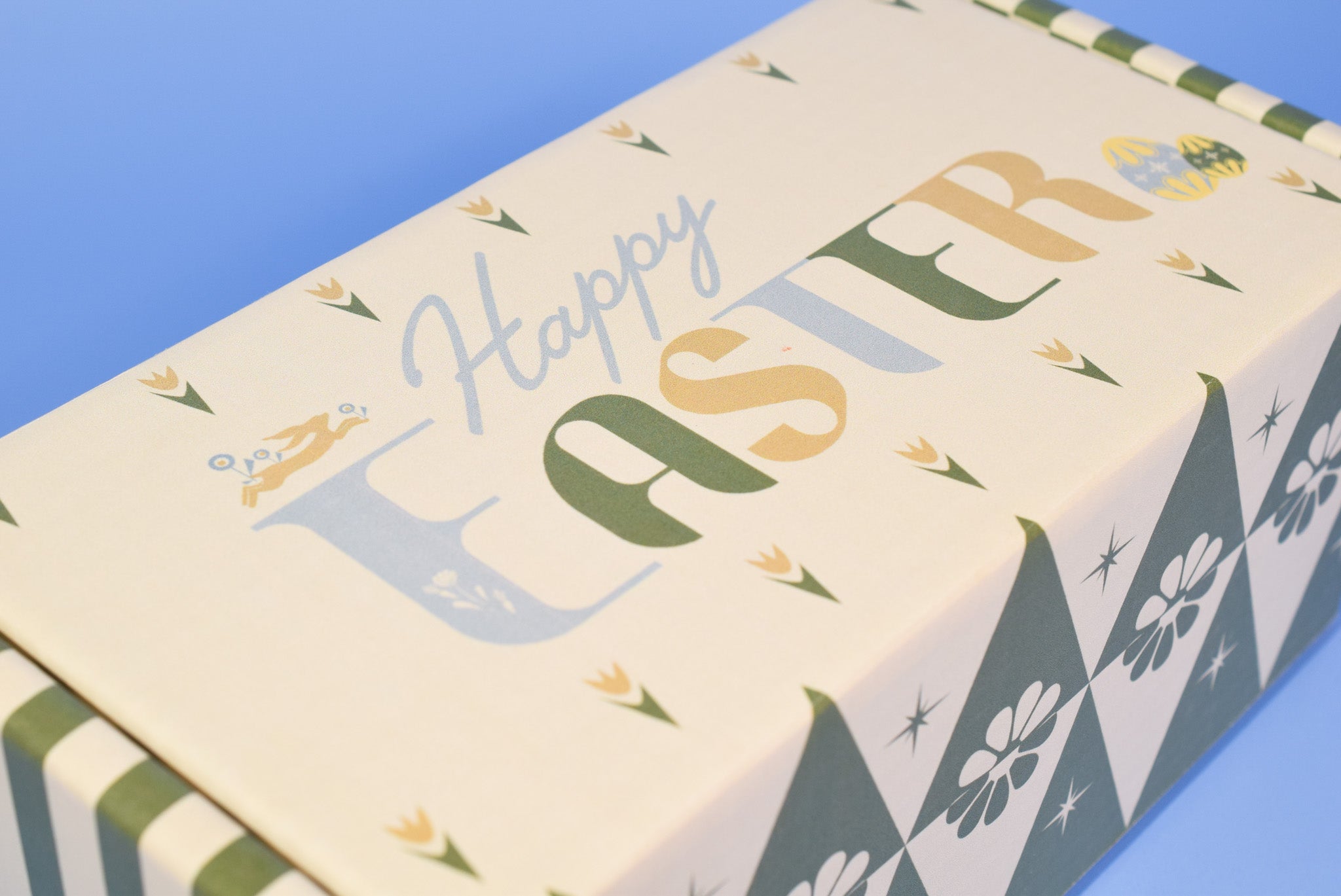 A close up of the Easter themed cookie box on a blue background.