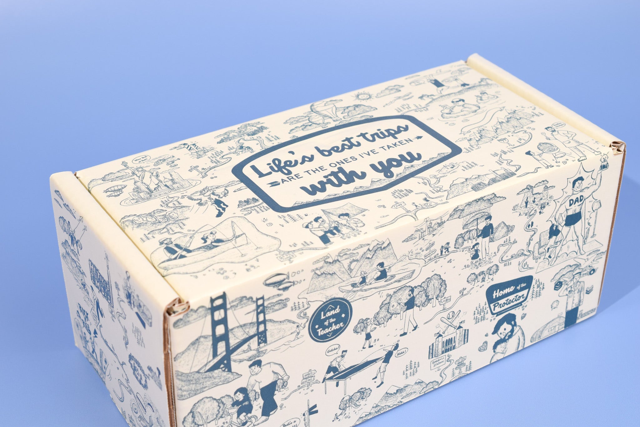 A keksi Father's Day cookie box with travel themed illustrations on a blue background.