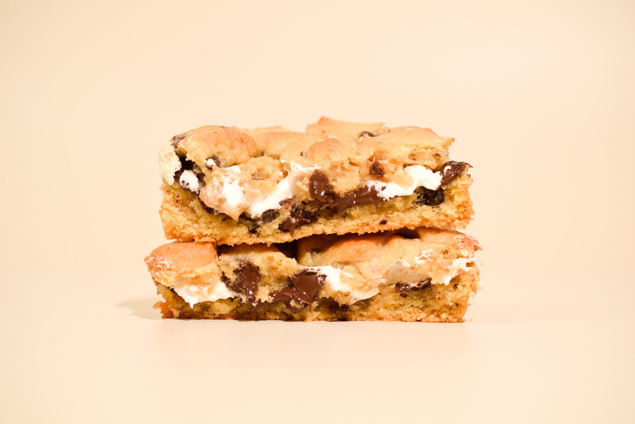 Two s'mores bars stacked on a beige background