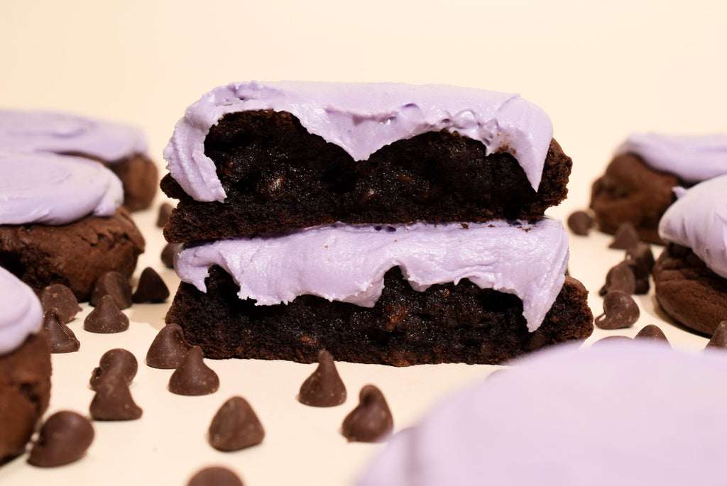 Ghoulberry (chocolate blackberry cookies) stacked on a cream background with scattered chocolate chips.