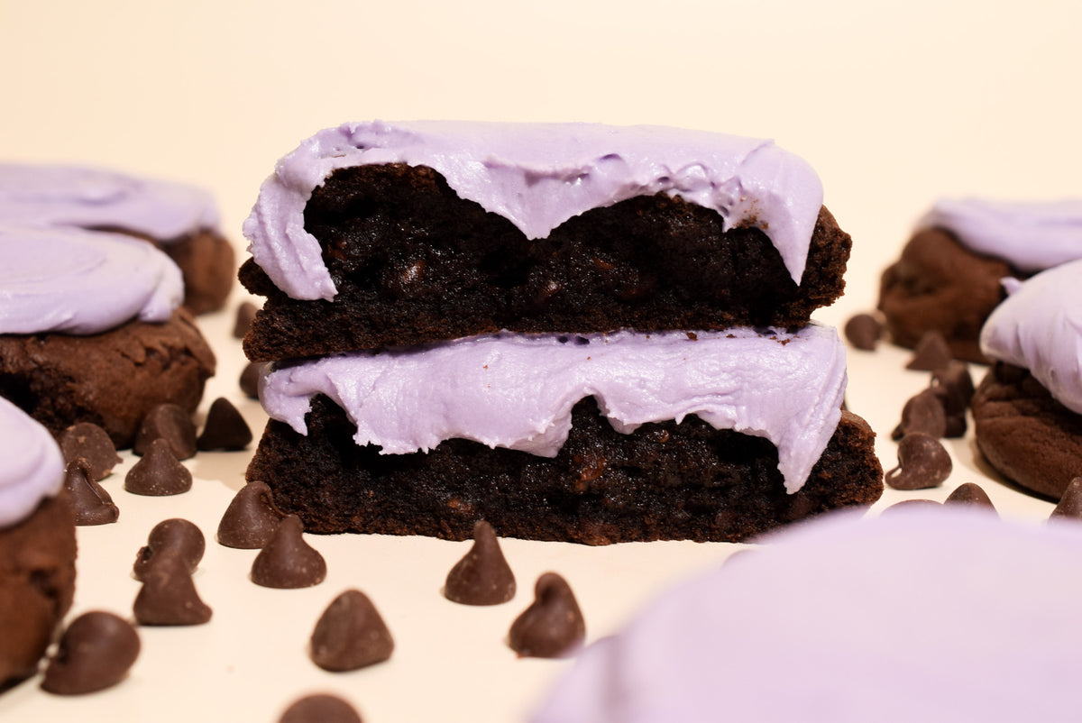 Ghoulberry (chocolate blackberry cookies) stacked on a cream background with scattered chocolate chips.