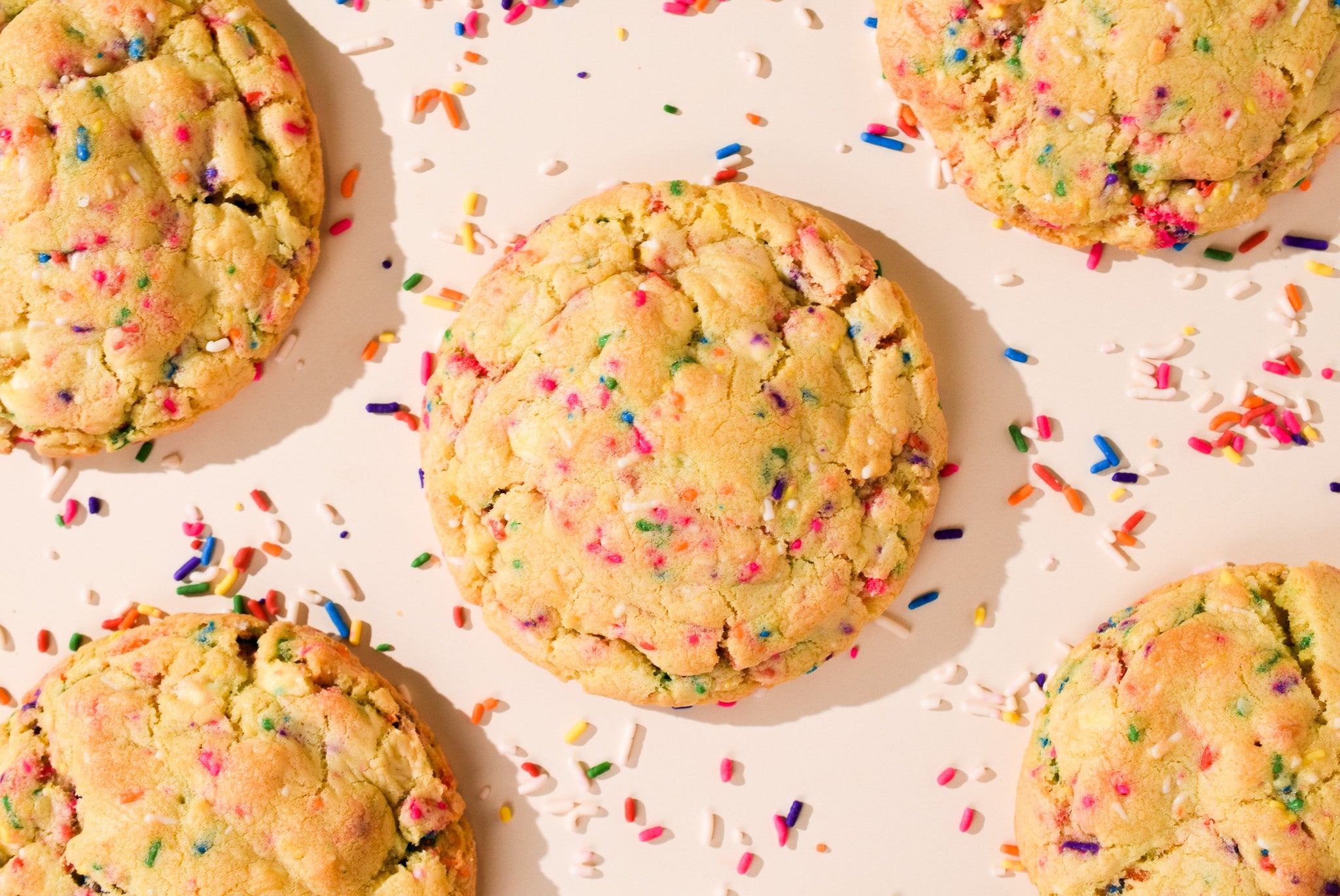 An overhead shot of Birthday Cake cookies with scattered rainbow sprinkles.