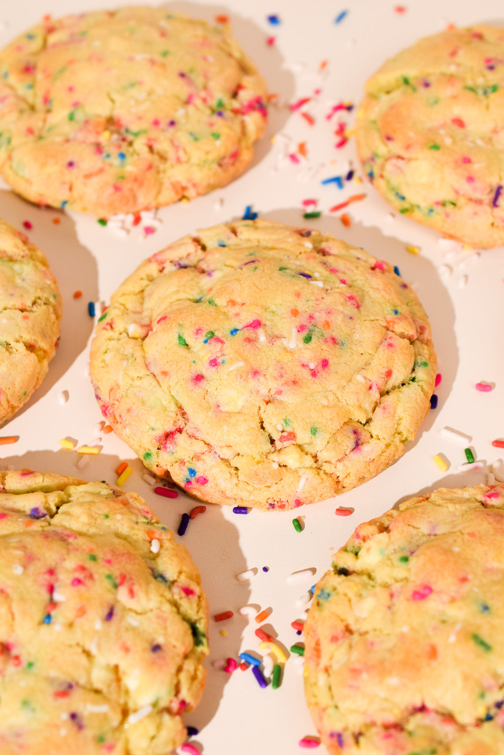 Cookies with colorful sprinkles on a cream background.