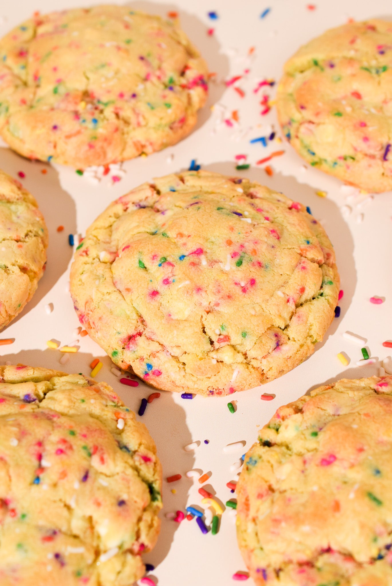Cookies with colorful sprinkles on a cream background.