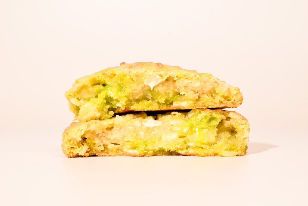 Two Key Lime Coconut Cookies stacked on a cream background.