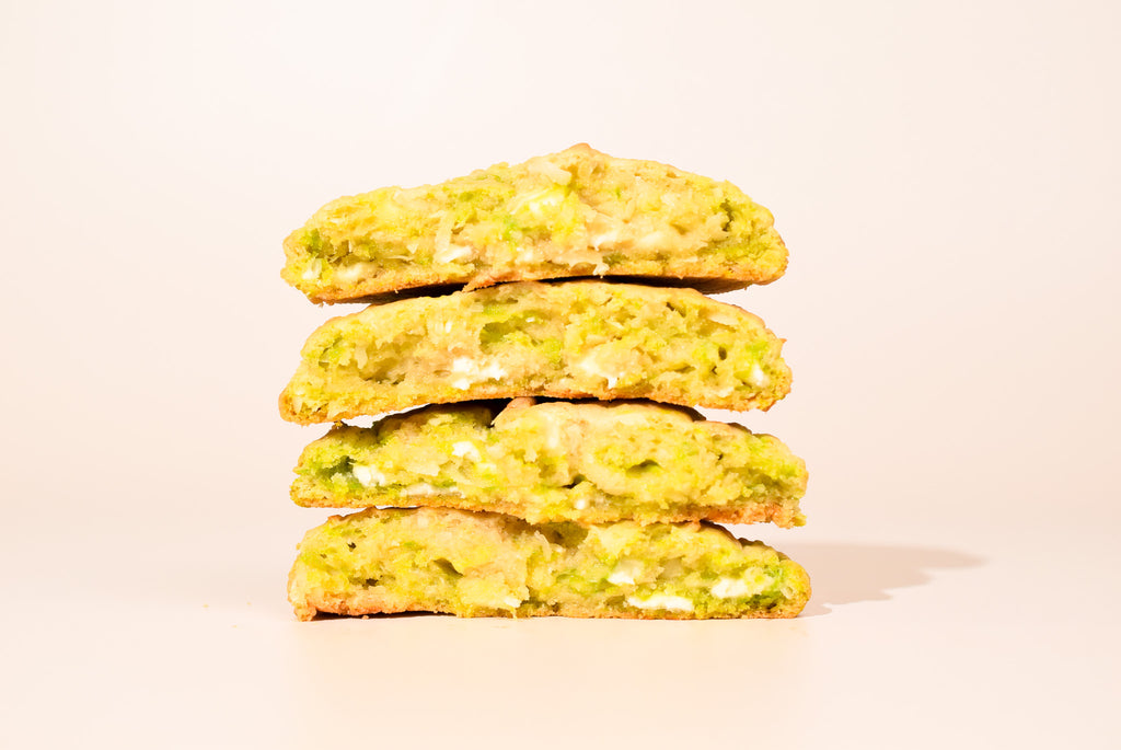 Four Key Lime Coconut cookies stacked on a cream background.