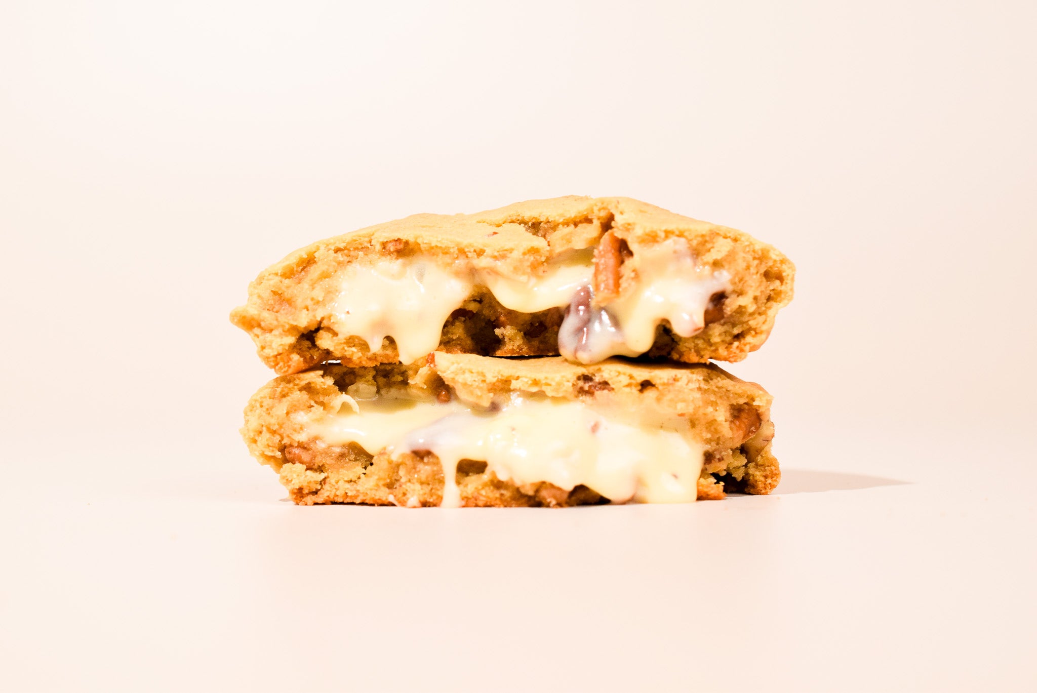 Pralines & Cream cookies stacked on a cream background.