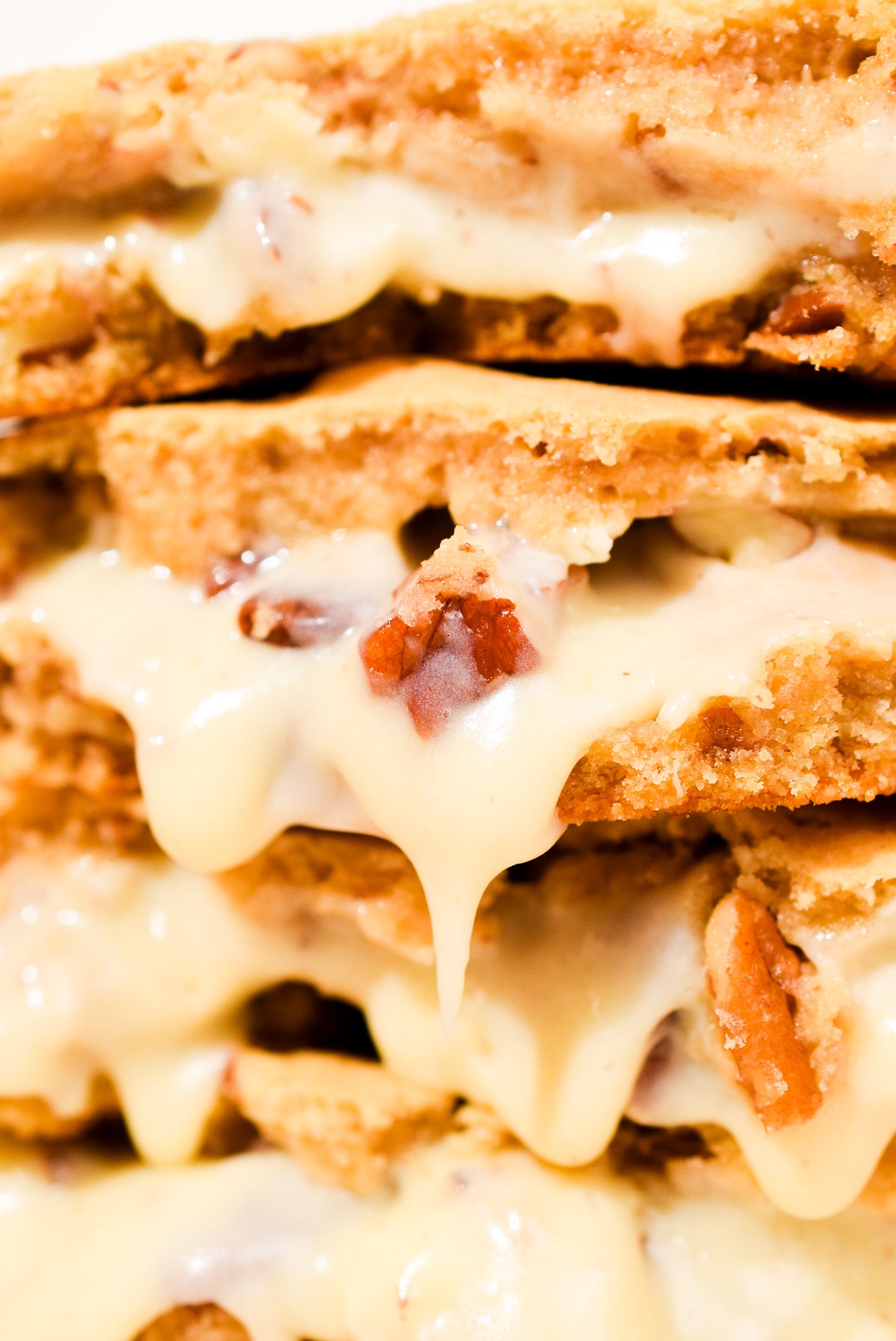 A close up of Pralines & Cream cookies stacked on a cream background.