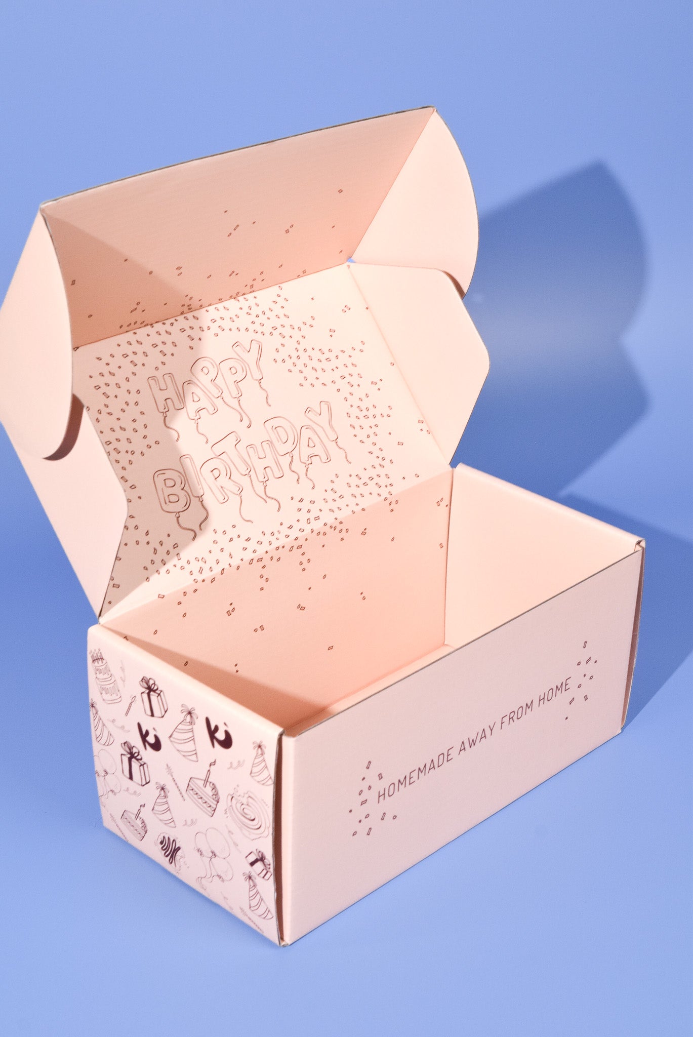An opened birthday cookie box on a blue background.