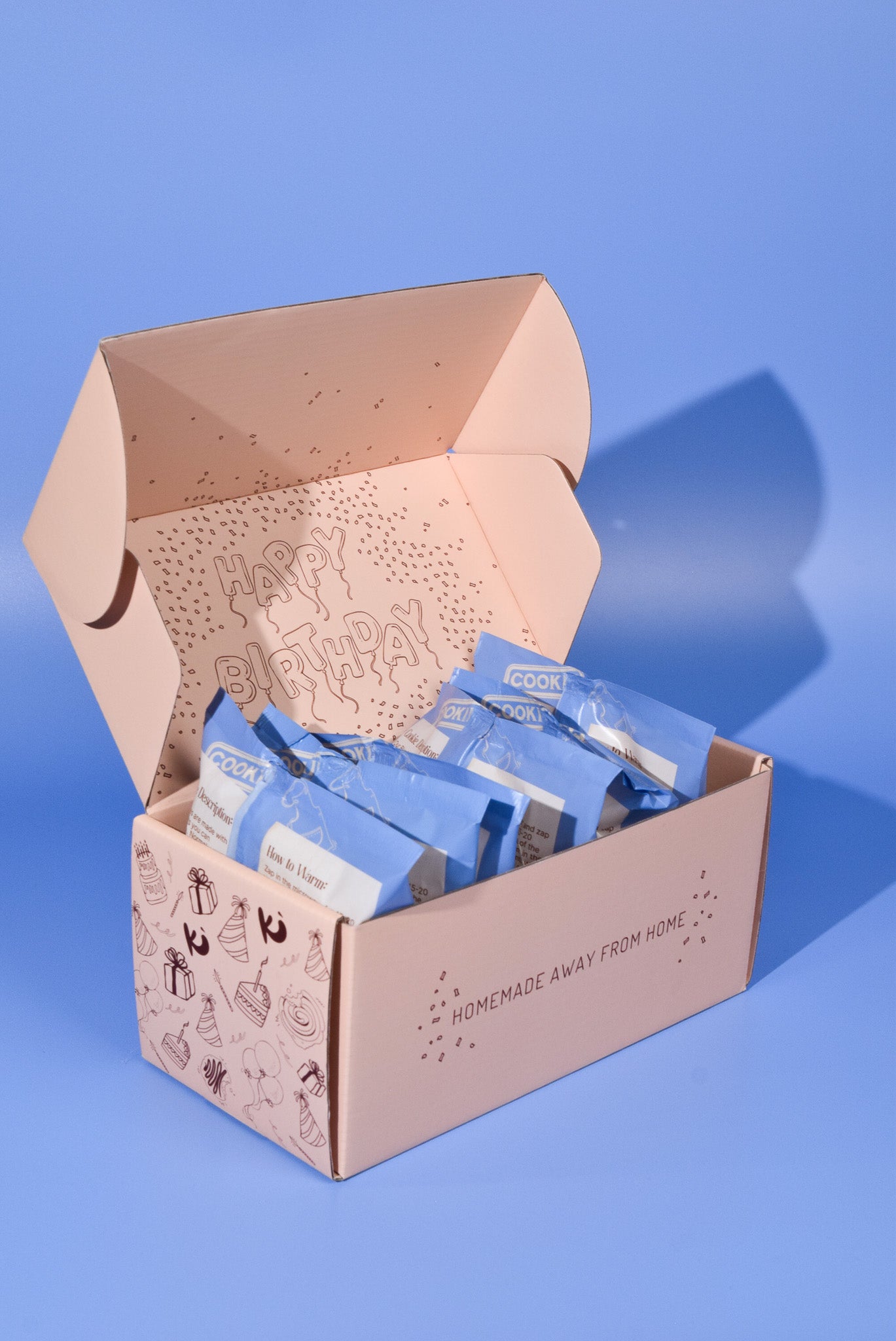 An opened birthday cookie box on a blue background.
