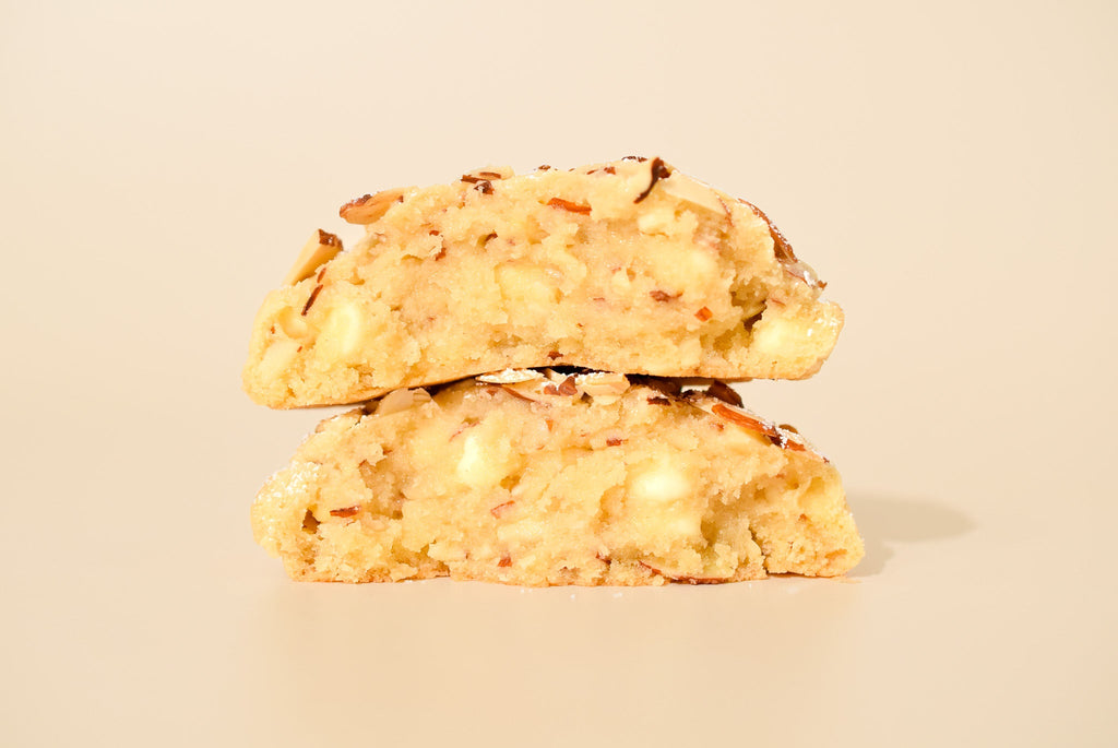 Two Almond Croissant cookies stacked on a cream background.