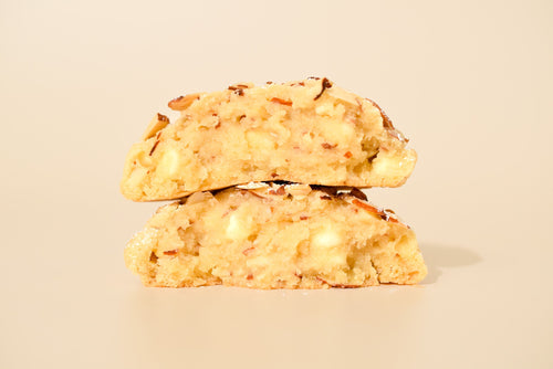 Two Almond Croissant cookies stacked on a cream background.